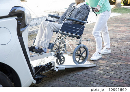 福祉車両に車椅子の高齢者を乗せるヘルパー 50095669
