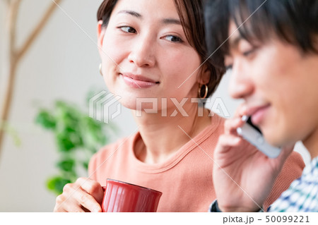 ソファでくつろぐ夫婦　夫が怪しい 50099221