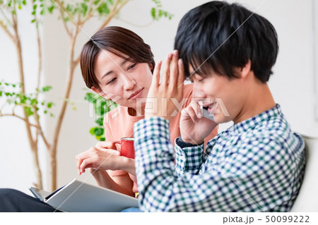 ソファでくつろぐ夫婦　夫が怪しい 50099222