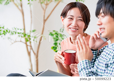 ソファでくつろぐ夫婦　夫が怪しい 50099223