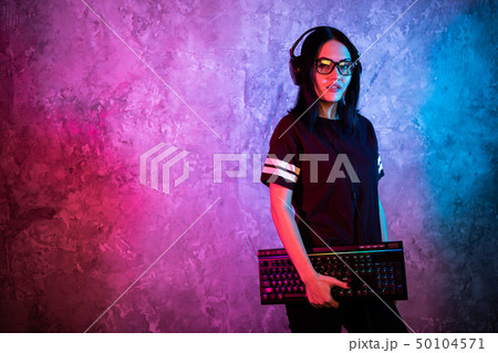 Gamer girl playing with computer at home. Young female posing with computer keyboard. Gamer girl playing with computer at home. Young female posing with computer keyboard. 50104571