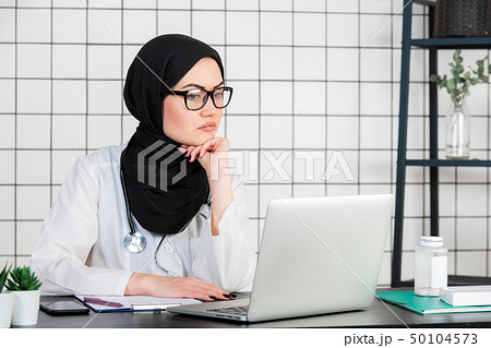 Middle age senior arab nurse woman wearing hijab at medical office with hand on chin thinking about 50104573