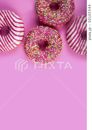 Pink donuts on a wooden background. 50105544