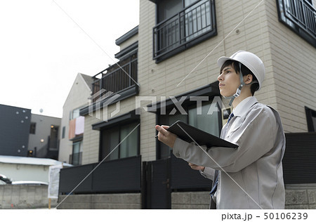 住宅とヘルメットの男性 現地調査の写真素材
