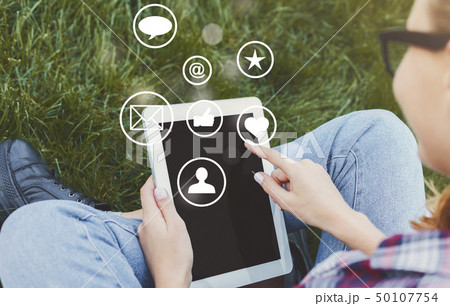 Woman touching tablet screen with virtual icons Woman touching tablet screen with virtual icons 50107754