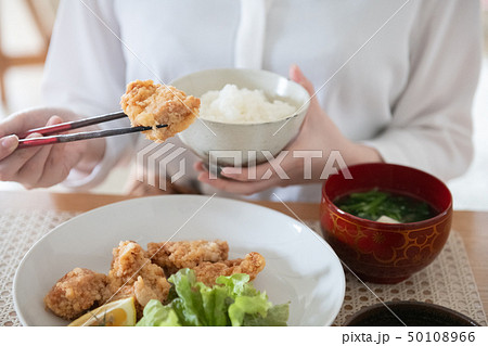 鶏の唐揚げを食べる若い女性の手元 50108966
