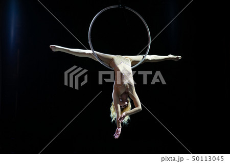 Graceful aerial acrobat doing her performance with a hoop isolated on black Graceful aerial acrobat doing her performance with a hoop isolated on black 50113045