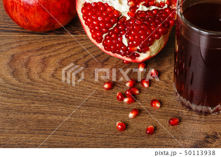 red pomegranate fruits, seeds and glass with juice 50113938
