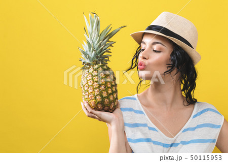 Happy young woman holding a pineapple Happy young woman holding a pineapple 50115953