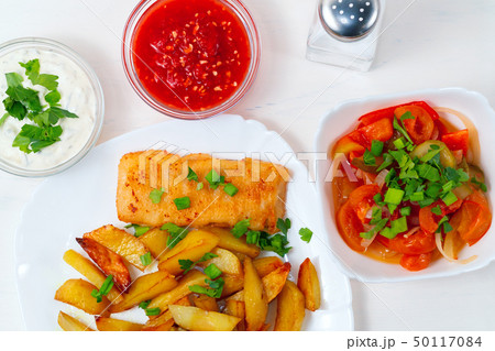 Fried fish and chips on a white plate 50117084
