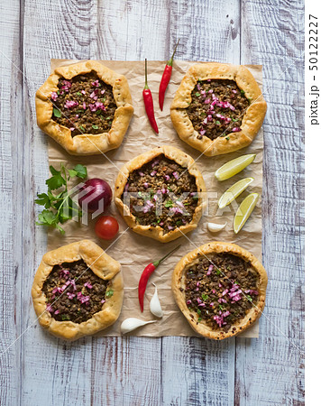 Open meat pies on a black background. Top view. Open meat pies on a black background. Top view. 50122227