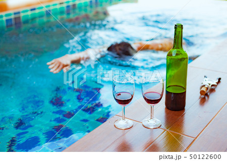 Two glasses of red wine near the swimming pool Two glasses of red wine near the swimming pool 50122600