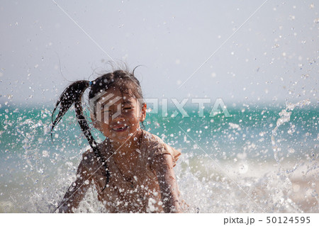 asian child girl having fun to play water in sea asian child girl having fun to play water in sea 50124595