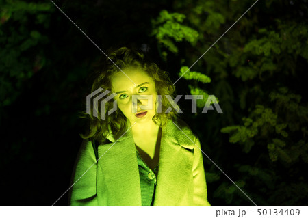 Portrait of a mysterious beautiful woman in green lighting. Portrait of a mysterious beautiful woman in green lighting. 50134409