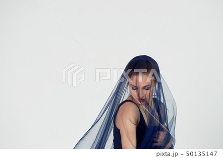 A slender gymnast in black tights dances with a blue chiffon that develops.Aesthetics of dance A slender gymnast in black tights dances with a blue chiffon that develops.Aesthetics of dance 50135147