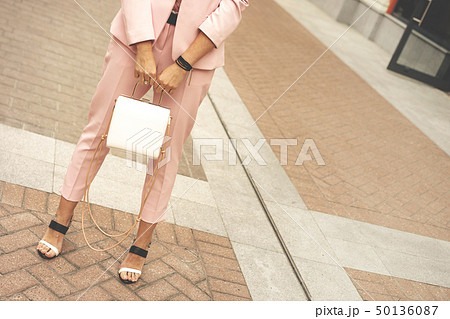 A woman in fashionable pantsuit pale pink dusty color A woman in fashionable pantsuit pale pink dusty color 50136087