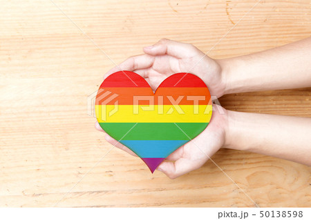 Human hands holding heart with rainbow flag Human hands holding heart with rainbow flag 50138598
