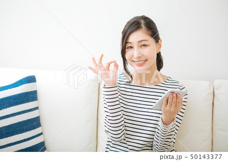 スマホを持ってオッケーサインをする女性 50143377