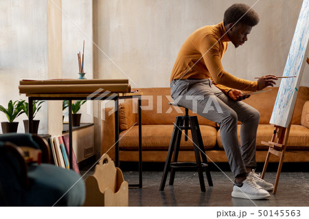 Nice hard working artist concentrating on his painting 50145563