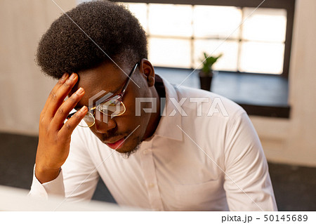 Serious nice young man touching his forehead Serious nice young man touching his forehead 50145689