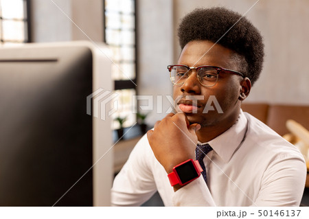 Serious smart young man touching his chin 50146137