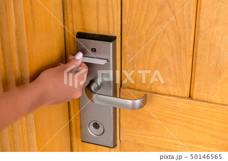 Woman hand with keycard in the electronic lock. Woman hand with keycard in the electronic lock. 50146565