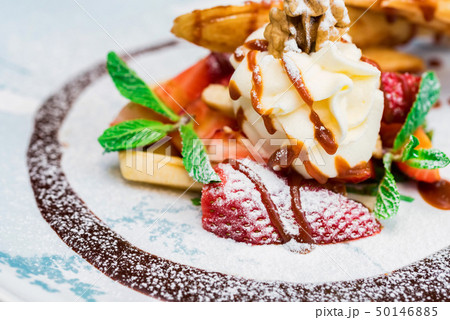 Close up delicious dessert with waffle rolls, ice cream and strawberries Close up delicious dessert with waffle rolls, ice cream and strawberries 50146885