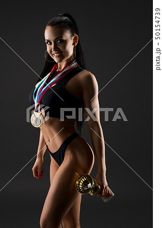 Fitness model with winner's cup and medal shot 50154739