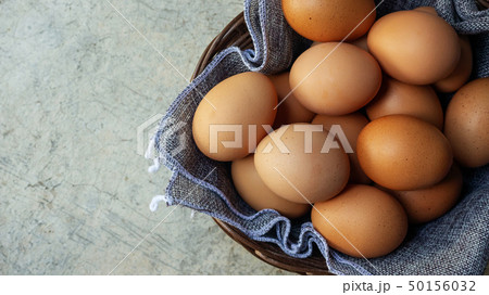 Chicken eggs in a basket on a gray background. 50156032