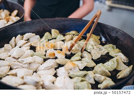 Dumplings with meat, onions on a big cast iron skillet. 50157472