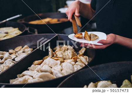 Dumplings with meat, onions on a big cast iron skillet. 50157473
