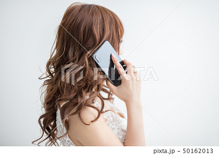 白背景に白いレースのドレスを着た美脚の女性が携帯電話を持っているモデル美人綺麗キャバクラキャバ嬢 50162013