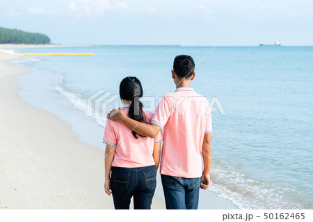 Couples walking on the beach on a summer vacation Couples walking on the beach on a summer vacation 50162465