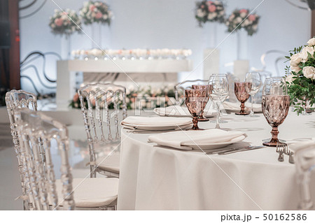 Flower arrangement in the center of the table. Interior of restaurant for wedding dinner, ready for 50162586