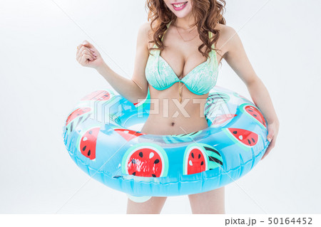 白背景で水着姿で浮き輪を持っている長い髪の茶髪の女性夏海リゾート 50164452
