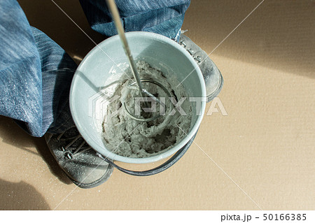 Man builder mixes gypsum putty 50166385
