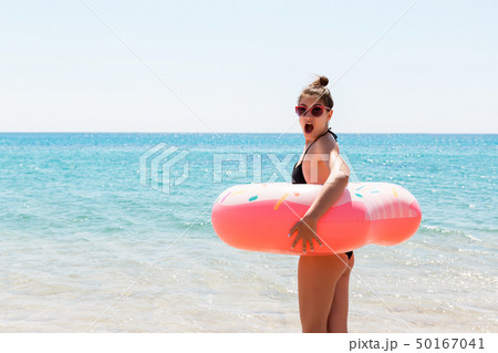 Woman relaxing with inflatable ring on the beach. 50167041