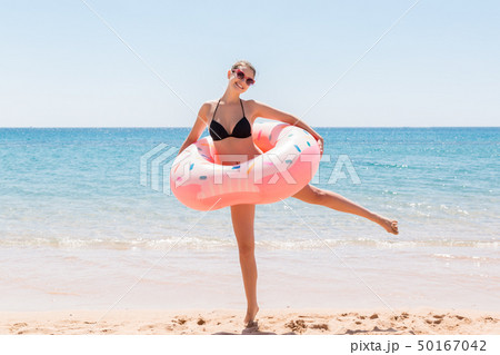 Woman relaxing with inflatable ring on the beach. 50167042
