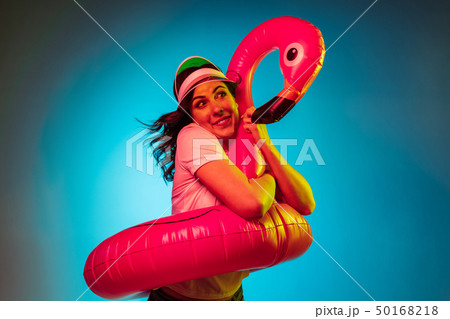 Happy young woman standing and smiling against blue background 50168218