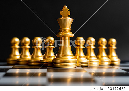 Gold king chess piece stand in front of pawn 50172622