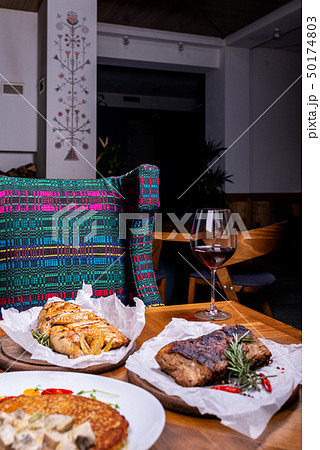 Different meat and a glass of wine in the interior of the restaurant 50174803