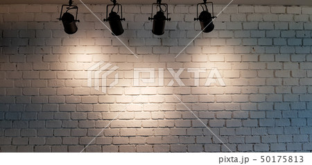 Hanging spotlight illuminate at white brick wall Hanging spotlight illuminate at white brick wall 50175813