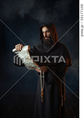 Medieval monk reads a prayer in ancient manuscript 50177106