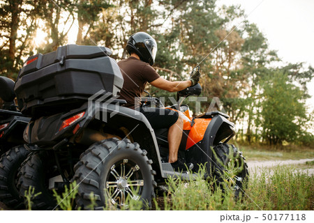 Rider in helmet on quad bike, front view, closeup 50177118