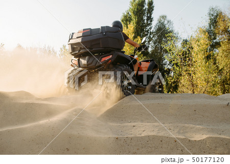 Atv riding in sand quarry, dust clouds, quad bike 50177120