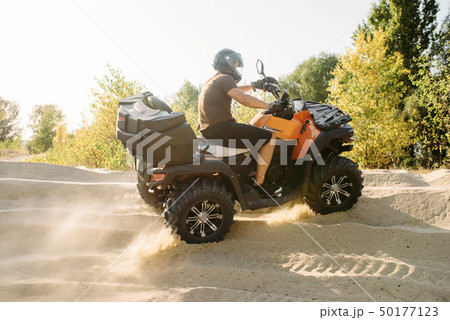 Atv riding in sand quarry, dust clouds, quad bike 50177123
