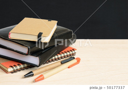 Notebooks and pens on wooden table with school Notebooks and pens on wooden table with school 50177337