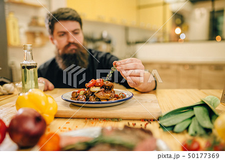 Chef decorates with herbs a meat dish for gourmets Chef decorates with herbs a meat dish for gourmets 50177369