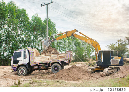 Yellow excavator machine loading soil into a dump Yellow excavator machine loading soil into a dump 50178626
