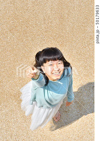 ビーチで貝殻を拾う女の子 50179633